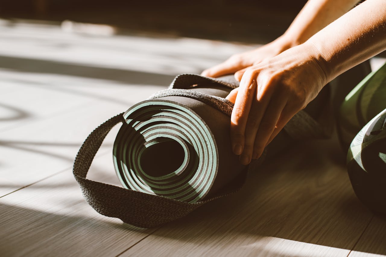 Person rollt eine Gymnastikmatte aus